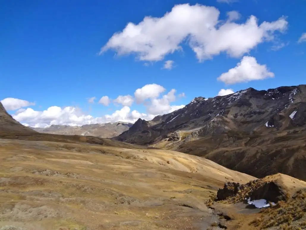 A view of a valley with mountains in the background during the Apu Ausangate trekking.