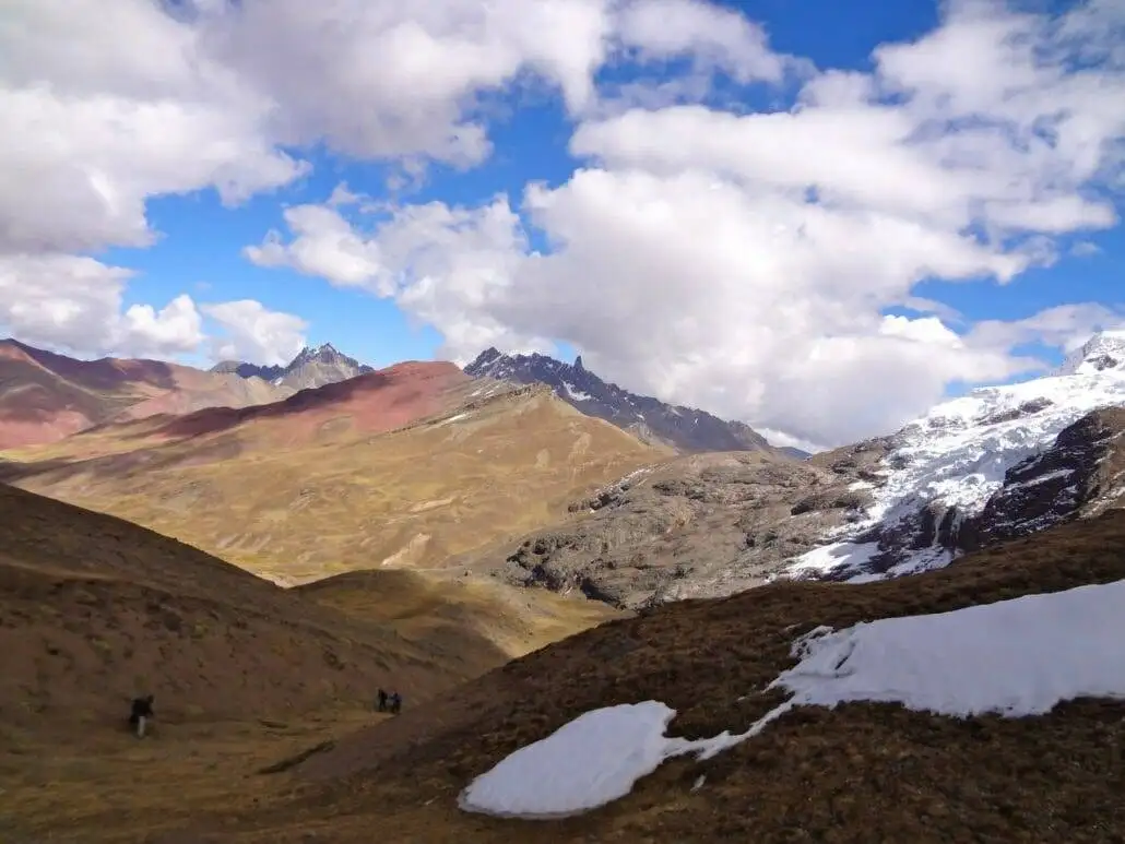Apu Ausangate trekking through a snow-covered mountain range.