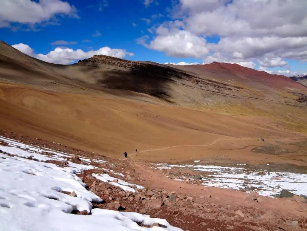 The Apu Ausangate trekking experience showcases snow-covered mountains.