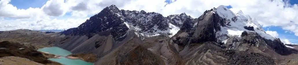 An aerial view of the Apu Ausangate mountain range with a lake.