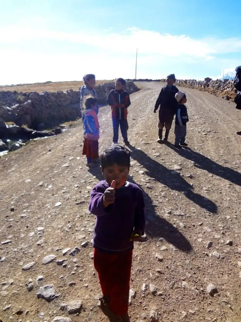 Apu Ausangate trekking, children standing on a dirt road.
