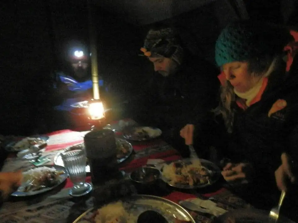 A group of people dining in a tent during the Apu Ausangate trekking adventure.