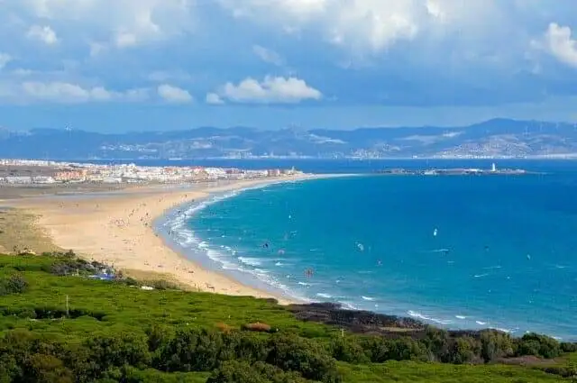 A picturesque beach in Tarifa with stunning views of trees and mountains.