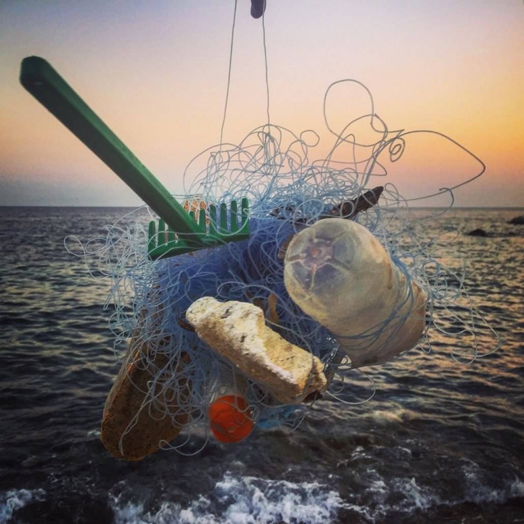A person is using a net for fishing while sailing.