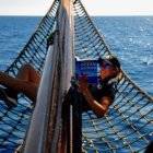 a woman reading a book on a sailboat.