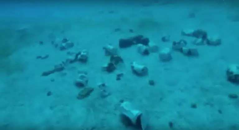 discarded plastic bottles left on sandy beach.
