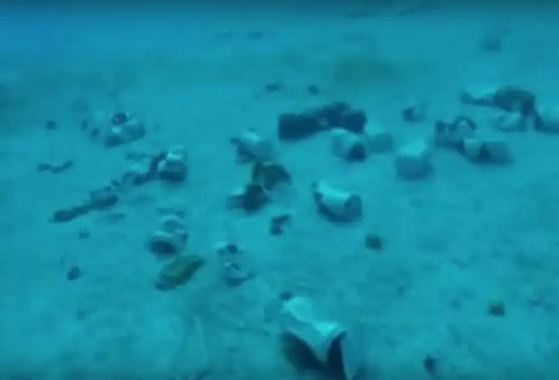 discarded plastic bottles left on sandy beach.