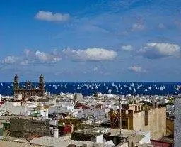 a view of a city with sailboats in the sky.