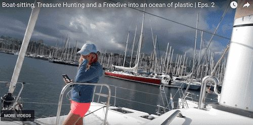 a woman is standing on a boat with a cell phone.