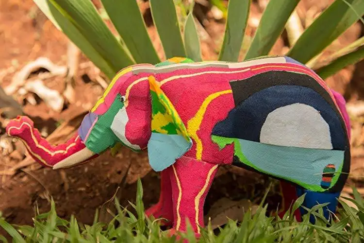 a vibrant elephant standing in the meadow with a plastic footwear alternative.