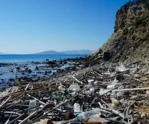 A polluted beach marred by trash, in need of the best water filtration for safe travel experiences.