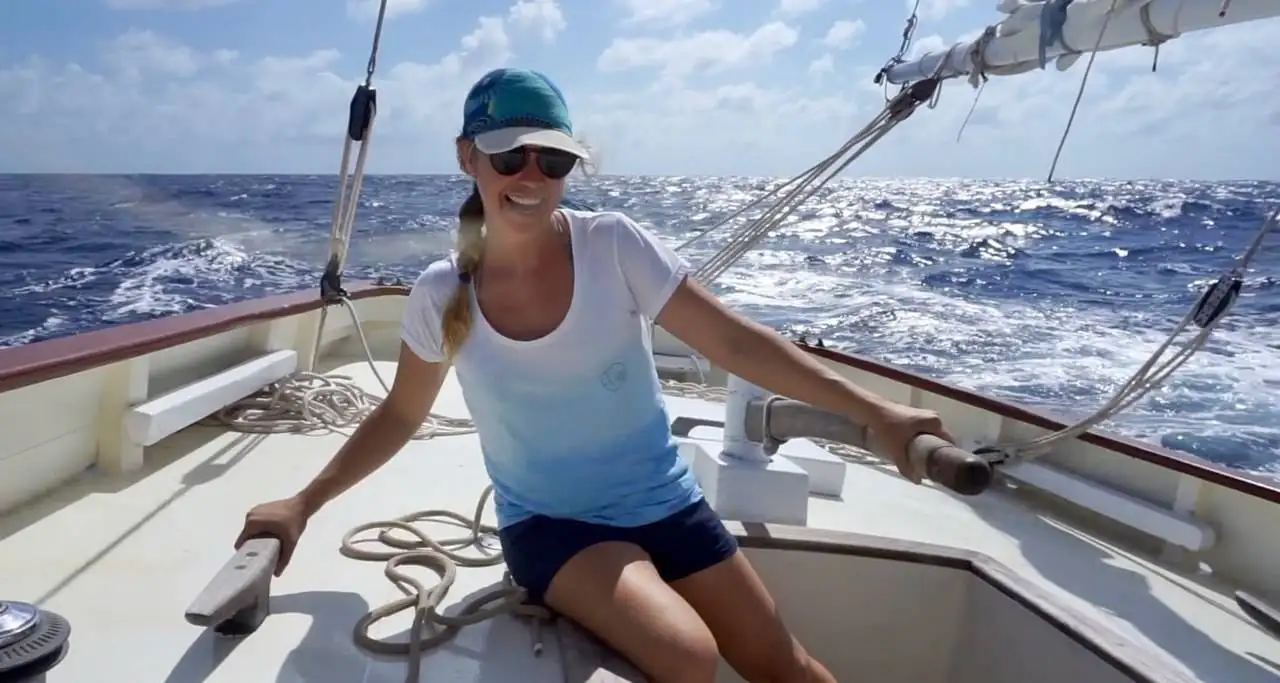 a woman sitting on the deck of a sailboat.