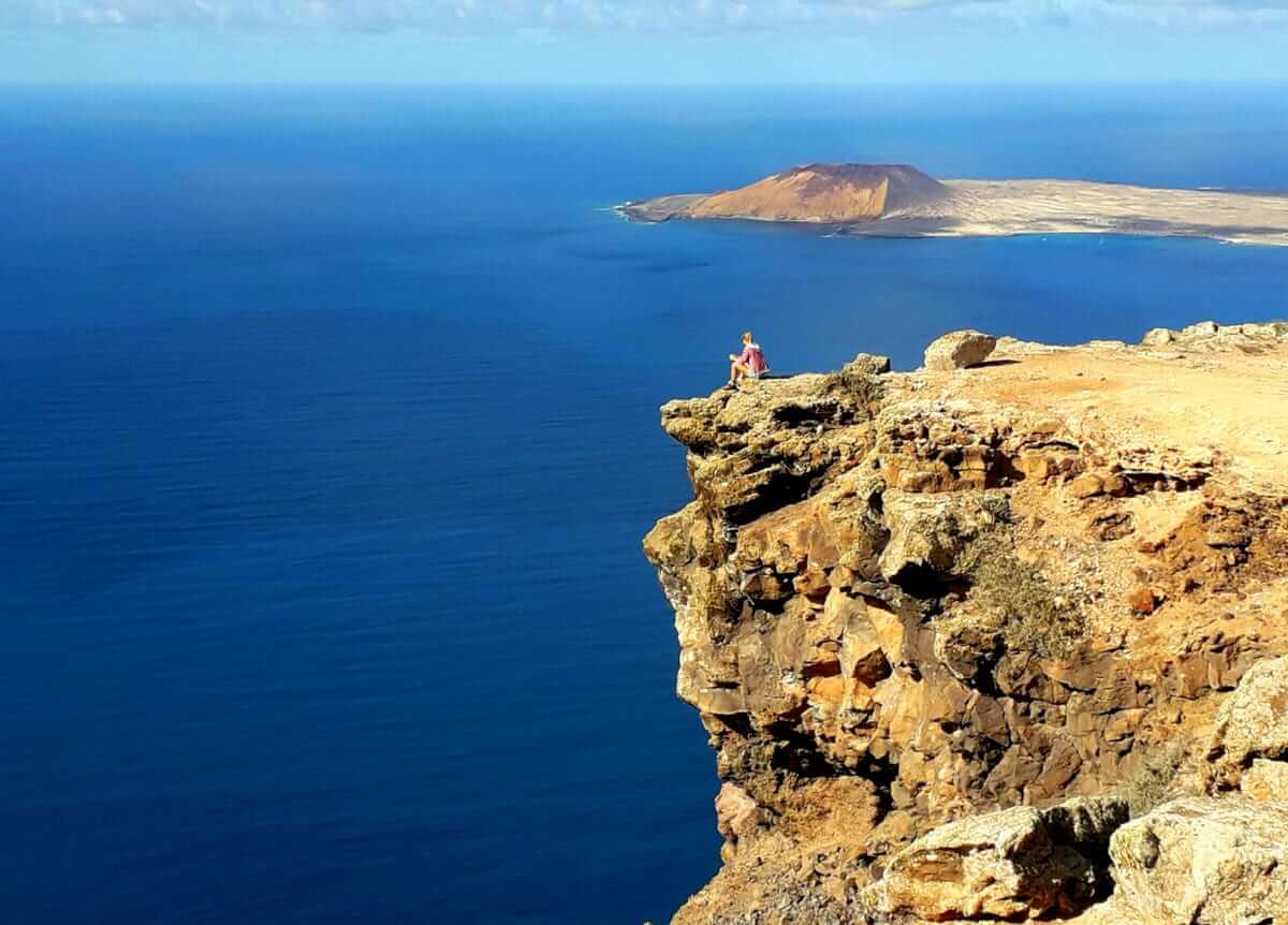 a person standing on a cliff overlooking the ocean.