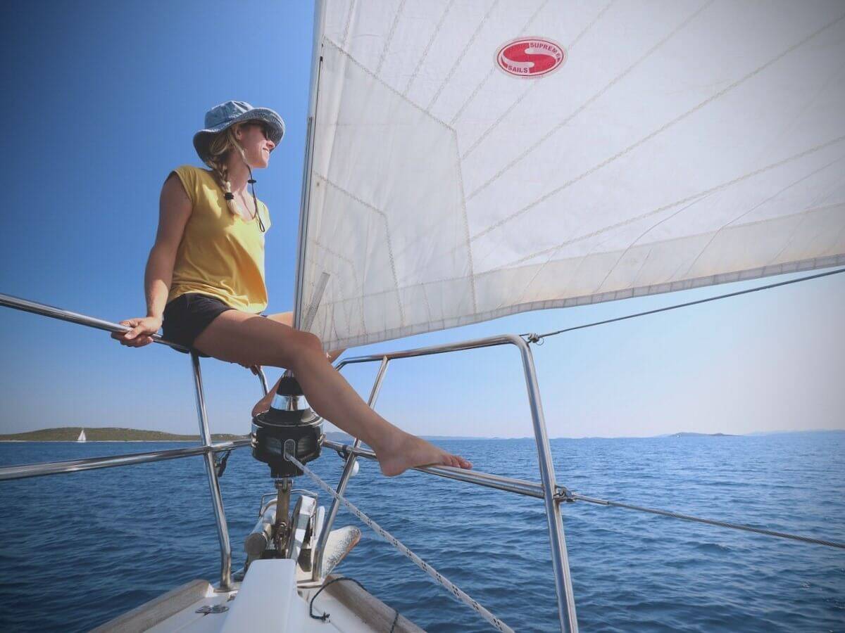 a woman sitting on the deck of a sailboat.