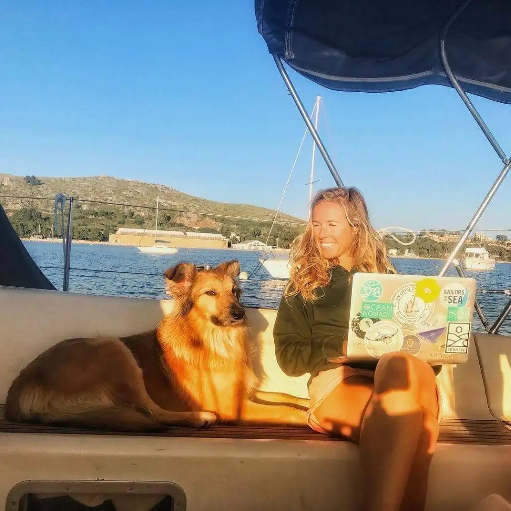 A woman seizing a sailing crew opportunity on a boat while accompanied by her loyal dog.