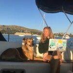 a woman enjoys the sailing experience on a boat with her dog.
