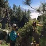 a woman hiking with her dog on a rocky trail.
