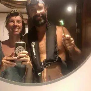 A man and woman taking a selfie with a Headlamp in a mirror.