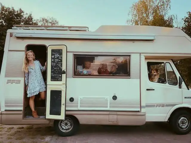Two women standing in the door of a Chalk Sticker camper van.
