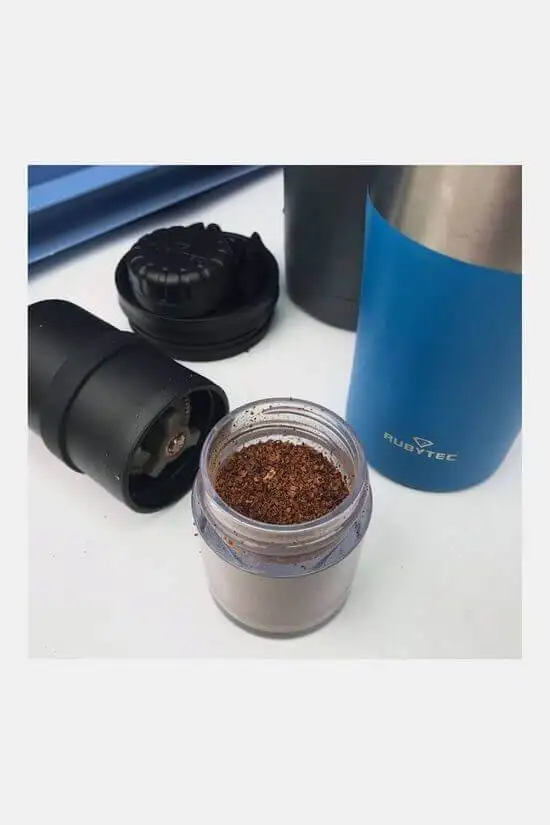Rubitec hand grinder for coffee and spices next to a mug in the van