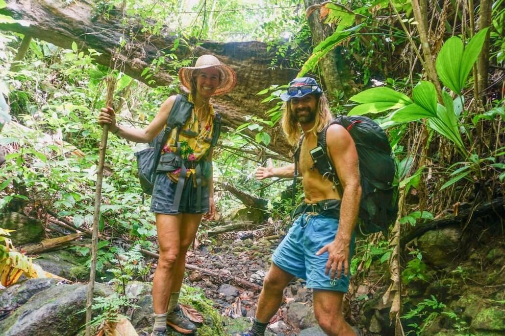 Two hikers standing on a trail in the jungle.