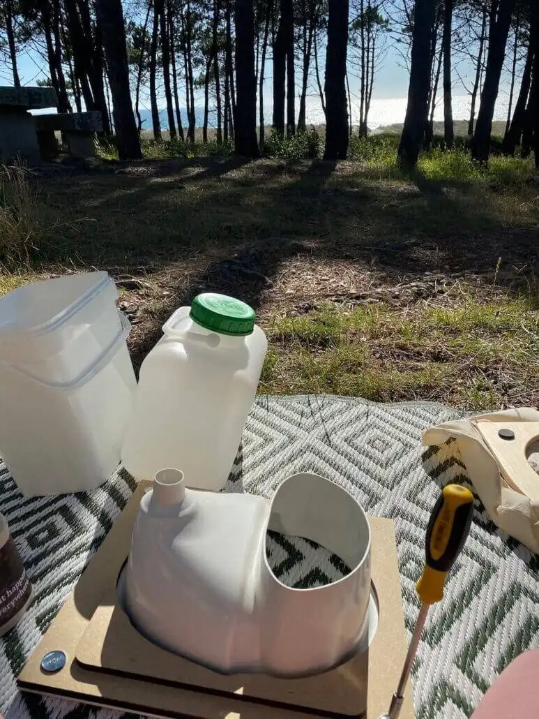 Outdoor camp scene with compost toilet cleaning setup
