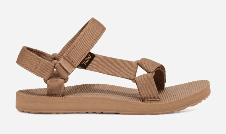 A pair of Teva Sandals with multiple tan webbing straps, an adjustable ankle strap, and a flat sole is displayed against a white background. The sandals also feature a small logo tag near the ankle. A pair of Teva Sandals with multiple tan webbing straps, an adjustable ankle strap, and a flat sole is displayed against a white background. The sandals also feature a small logo tag near the ankle.