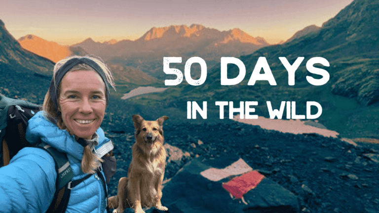 A woman in hiking gear and a dog pose on a rocky mountain trail at sunrise with "50 Days in the Wild" text overlaid on the image.