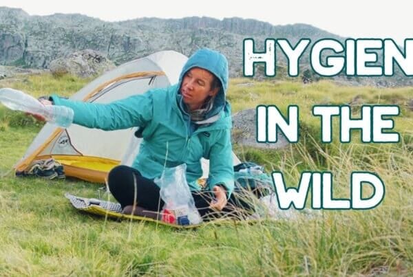 A person in outdoor gear sits by a tent in a grassy area, pouring water from a bottle. Large text reads, "Hygiene in the Wild.