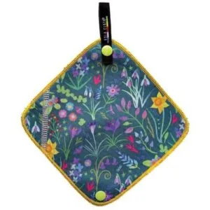The Kula Cloth (Pee rag) features a colorful floral pattern, yellow-edged border, two yellow snaps on opposite corners, and a black hanging loop with text; includes a leash.