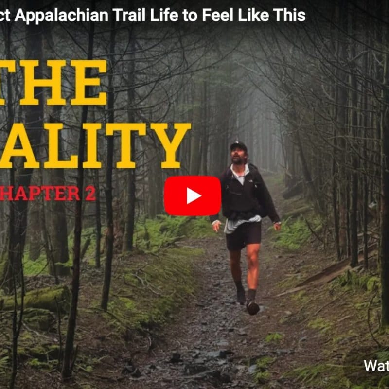 A person wearing a cap and hiking gear walks on a rocky forest trail, surrounded by leafless trees and green moss, with text reading "The Reality Chapter 2.