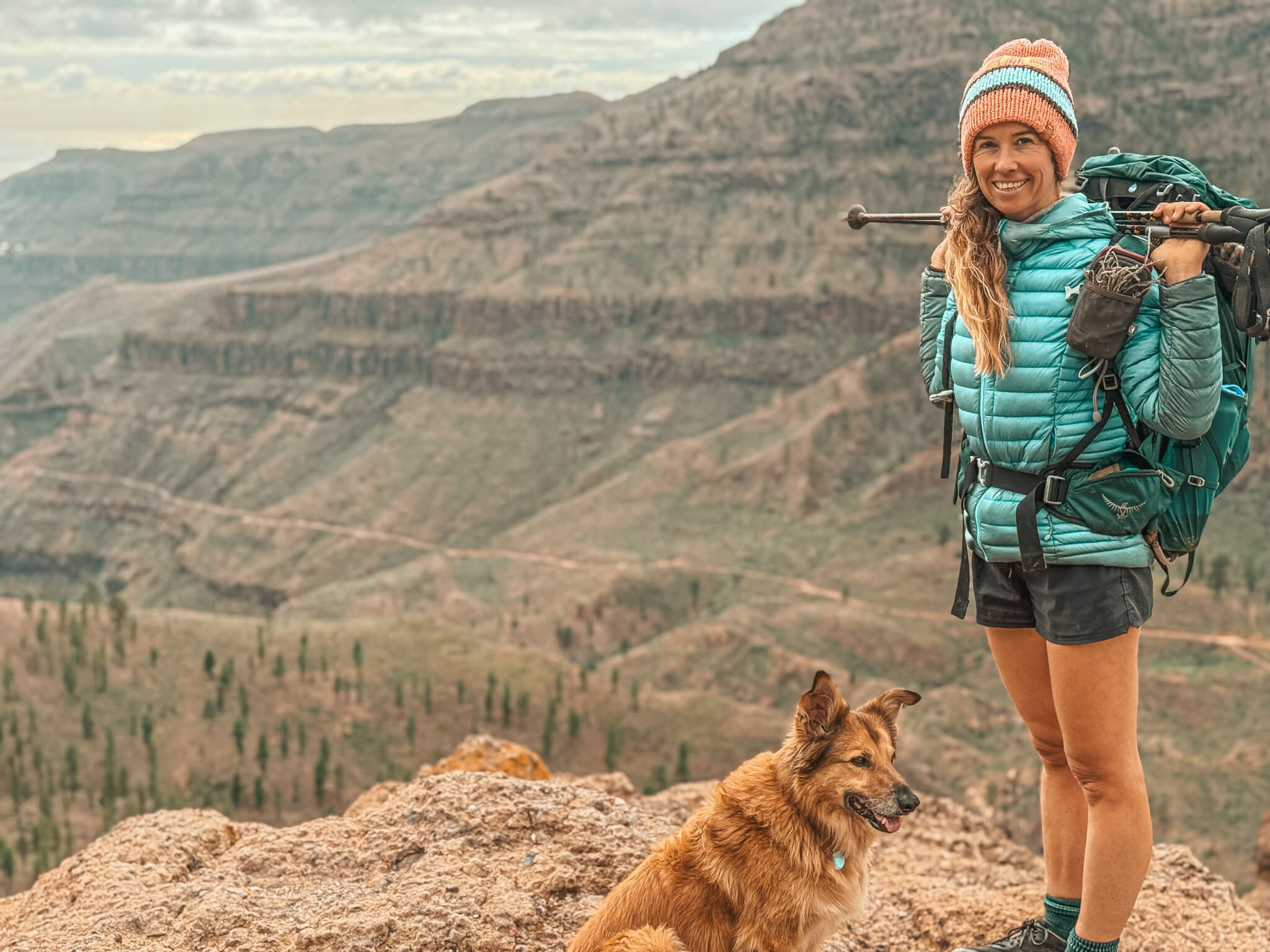 Suzanne hiking a multi-day trail with a loaded backpack and her dog