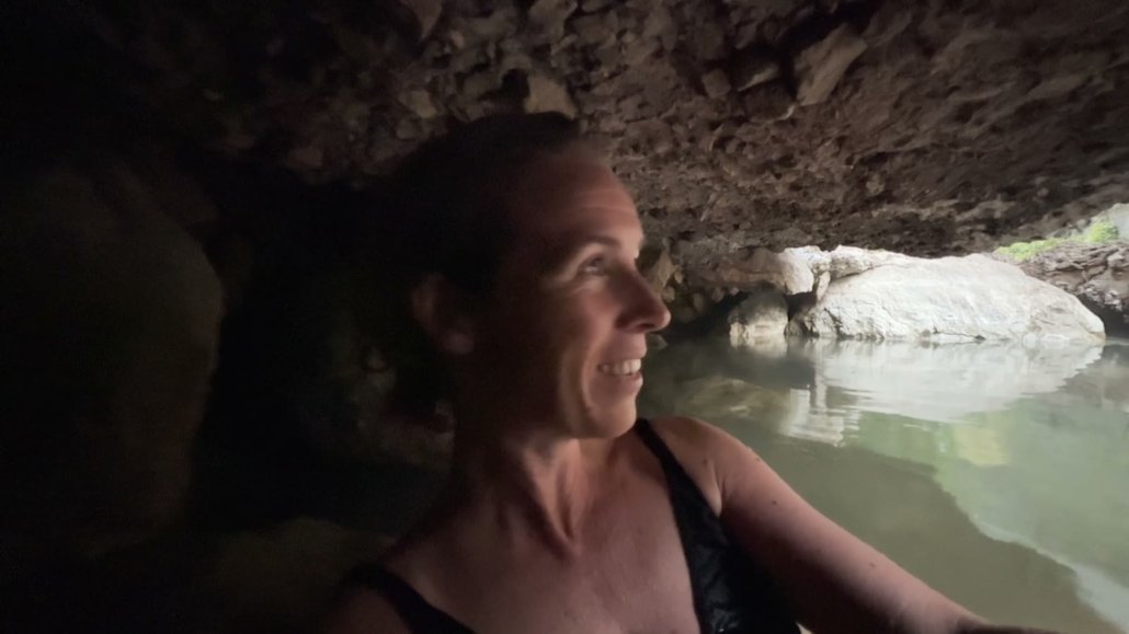Suzanne soaking in a hot spring under the rocks