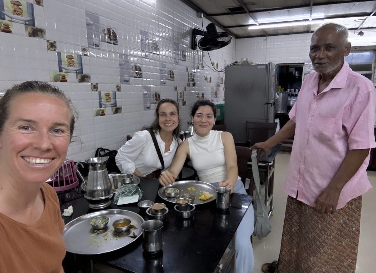 Suzanne with two fellow travellers and the owner in a small vegetarian restaurant in Fort Kochi