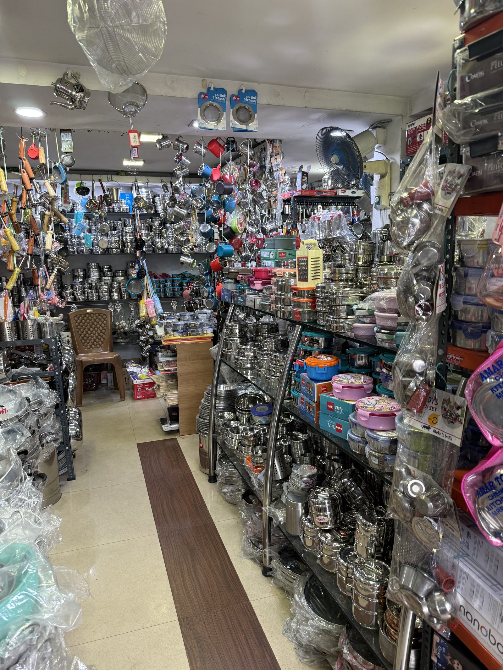 A shop in Kerala stacked floor to ceiling with stainless steel pots, plates and lunch boxes