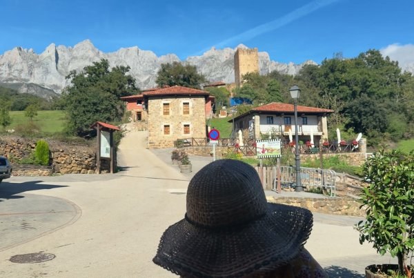 A stone village at the foot of the Picos de Europa, with the limestone peaks behind it