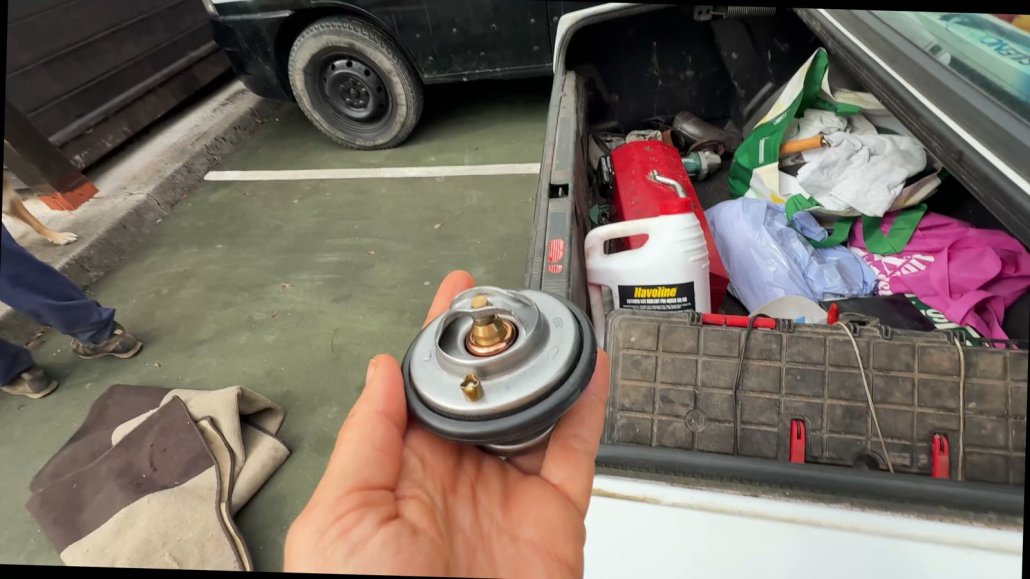 Holding the van thermostat before testing it in boiling water