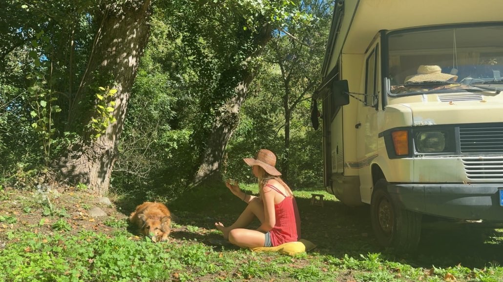 Suzanne and Wingo next to the old Mercedes van, parked under the trees by the river