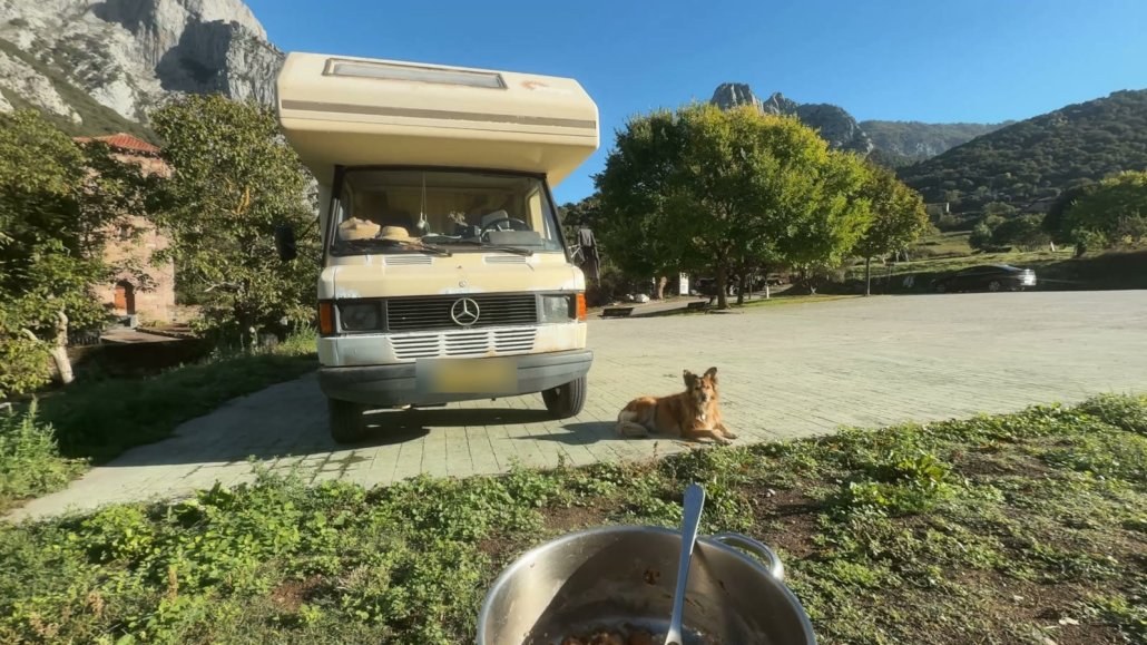 The old Mercedes van parked below the limestone peaks, with Wingo lying next to it